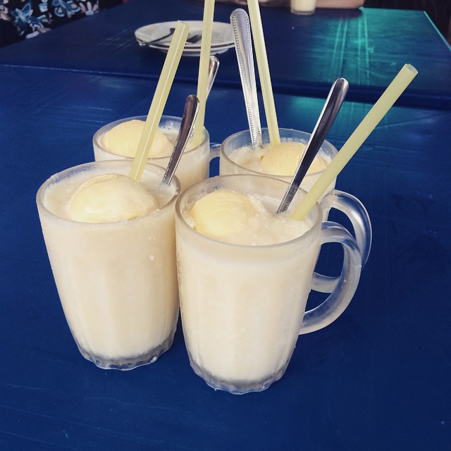 three cups filled with a liquid and straws