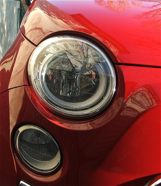 close up of an old red car with chrome grilles