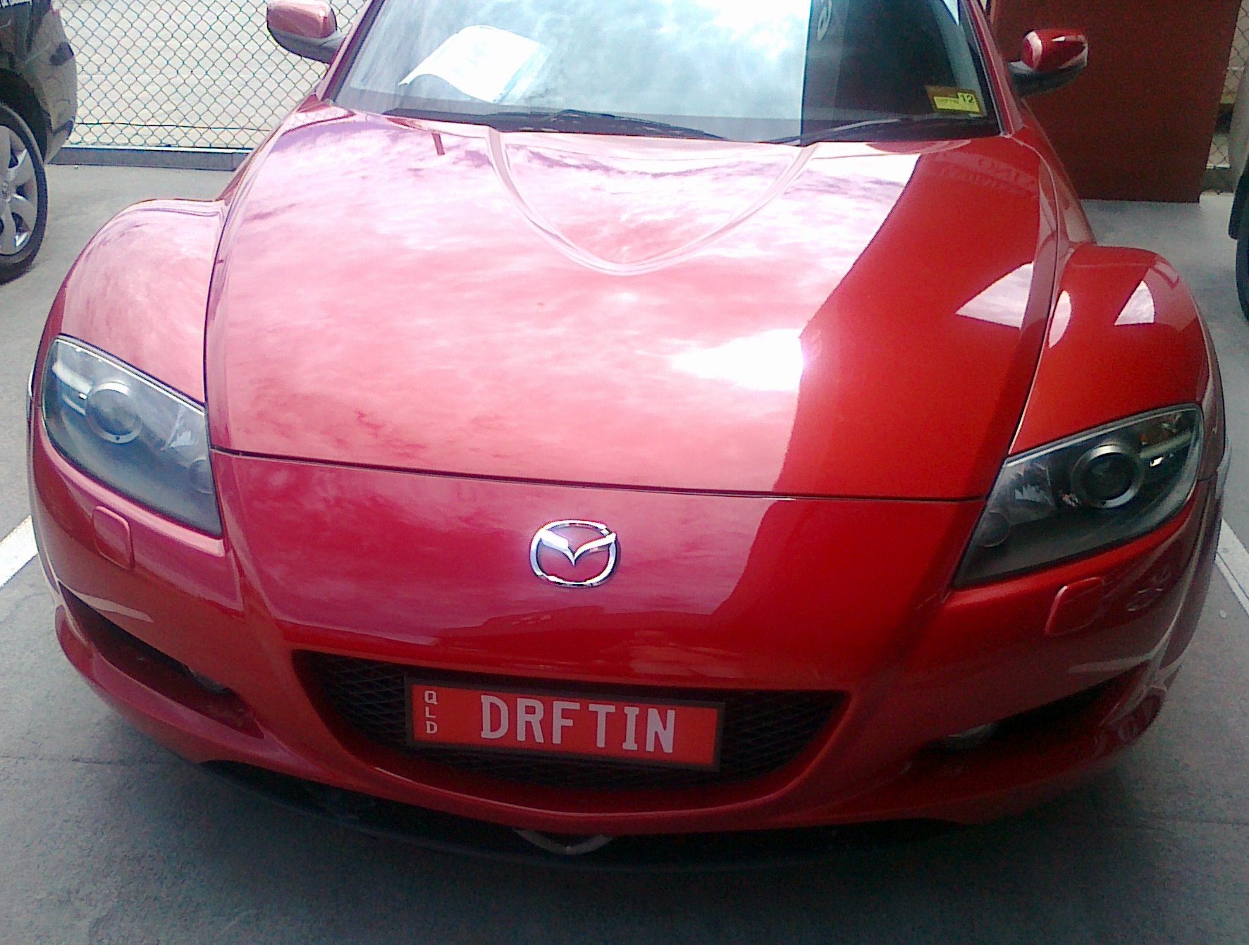 there is a red sports car parked in the lot