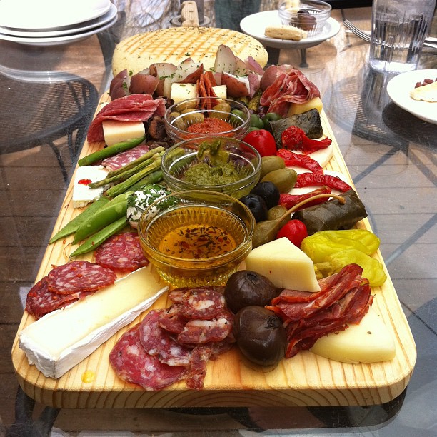 a table with many different meats, cheese and breads