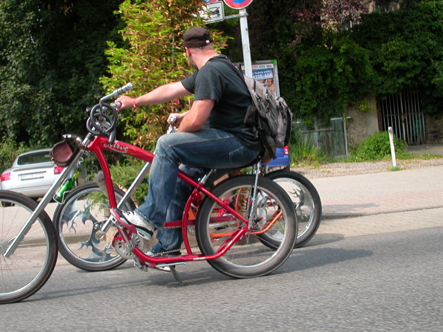a man in a black cap is riding a red bike