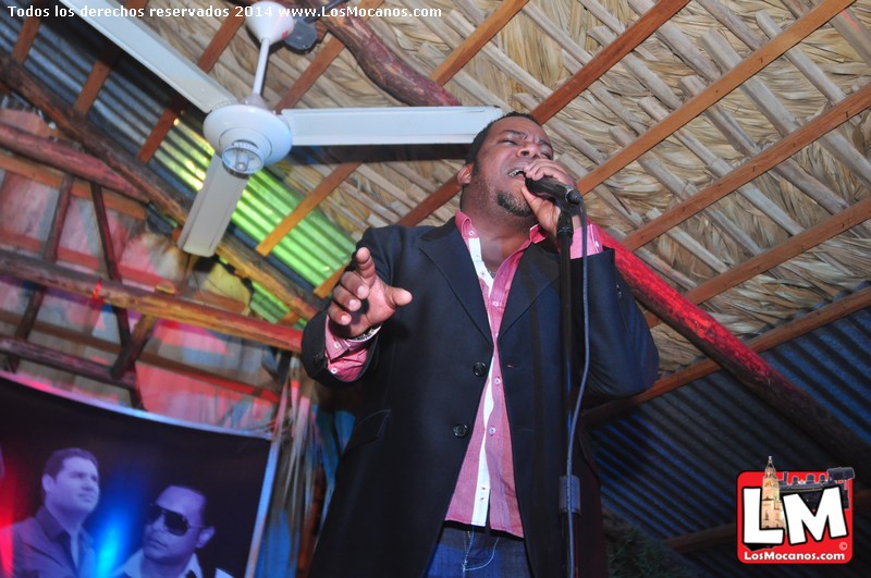 an african man holding a microphone and performing