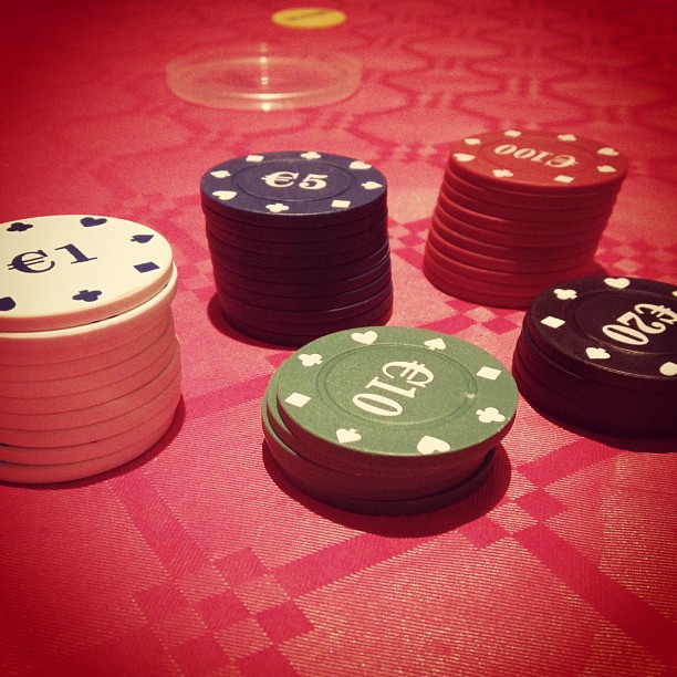 six poker chips, one with the number ten, are sitting on a table