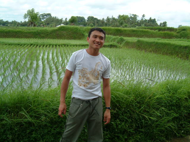 a young man standing next to a large patch of water