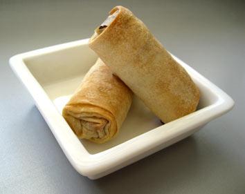 two rolled tortilla pieces on a square white tray