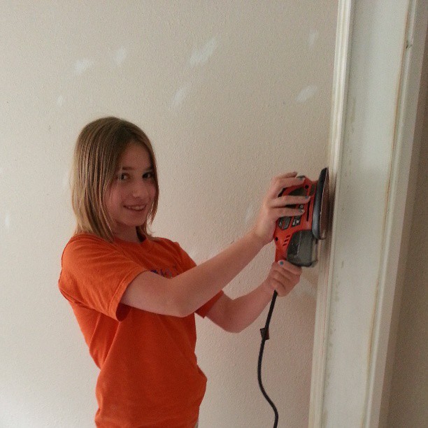 a woman holding a driller with an electric drill attached to it