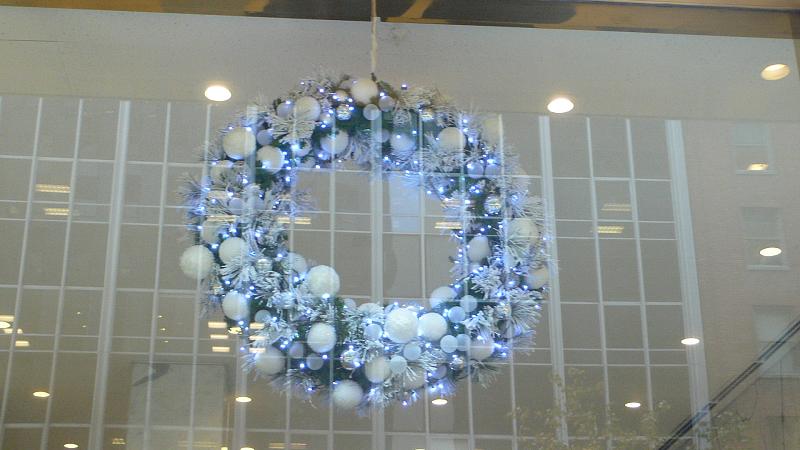 a glass wall covered in christmas wreaths and lights