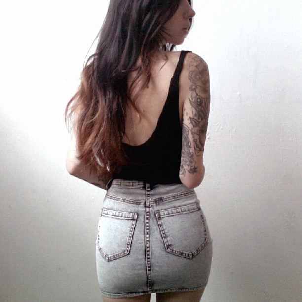 a girl with tattoos standing back to back