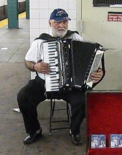 a man with white hair and beard playing an accordion