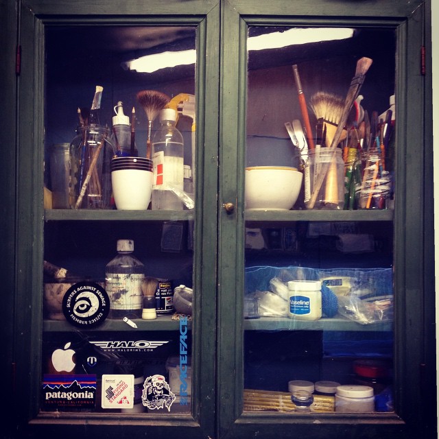 an old fashioned glass cabinet with dishes and toiletries behind it