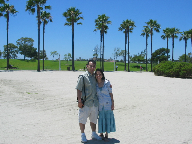 two people standing next to each other in the sand