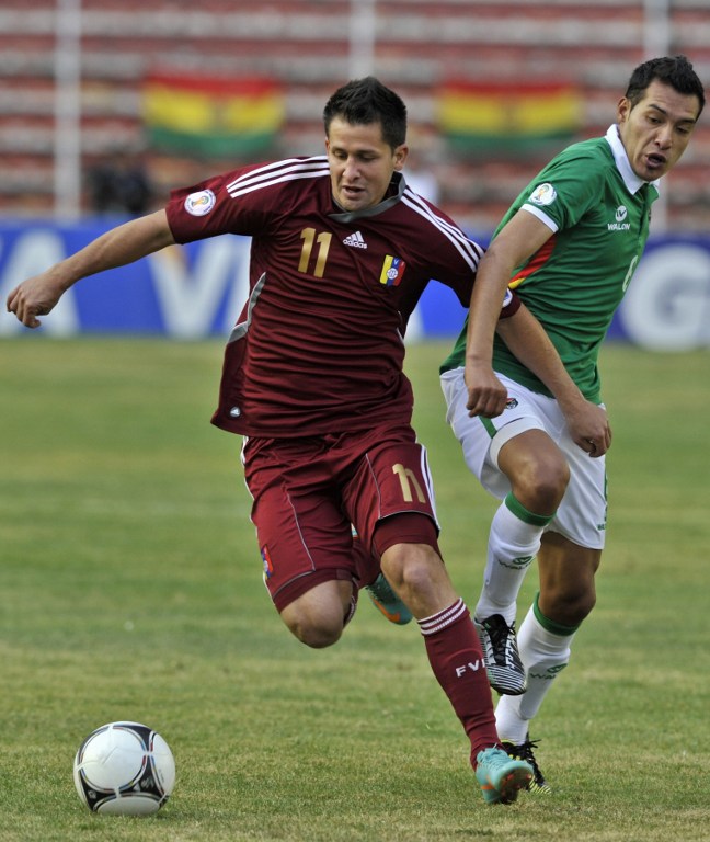 two soccer players are on the grass in front of the ball