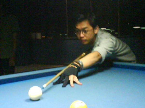 a man taking a s at a pool ball
