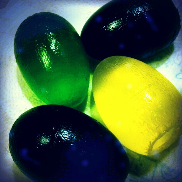 four dark eggs and one yellow egg next to each other