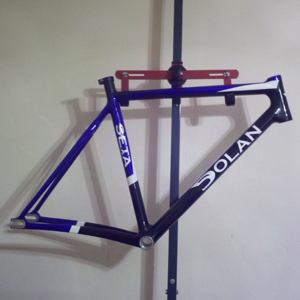 the blue frame and seatposts are hung on the wall