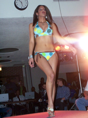 a woman in a colorful bikini walking across a stage