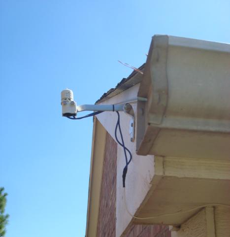 an overhead camera mounted to a house wall
