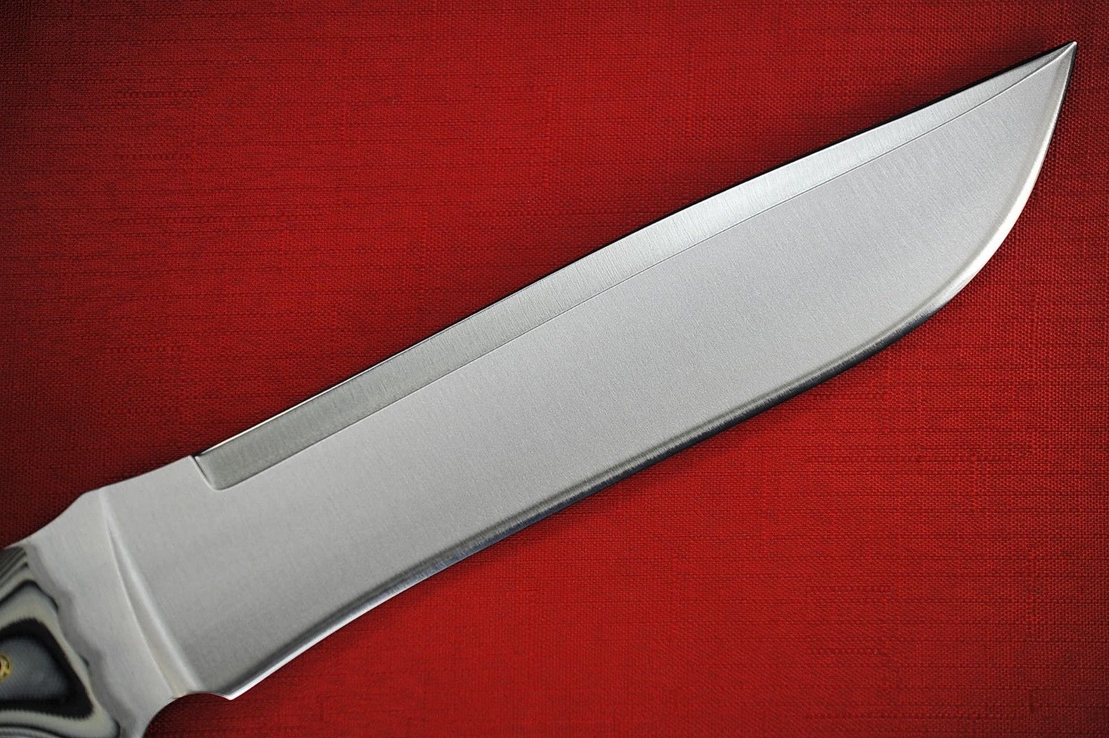 a large, metal knife with an blade on a red table cloth