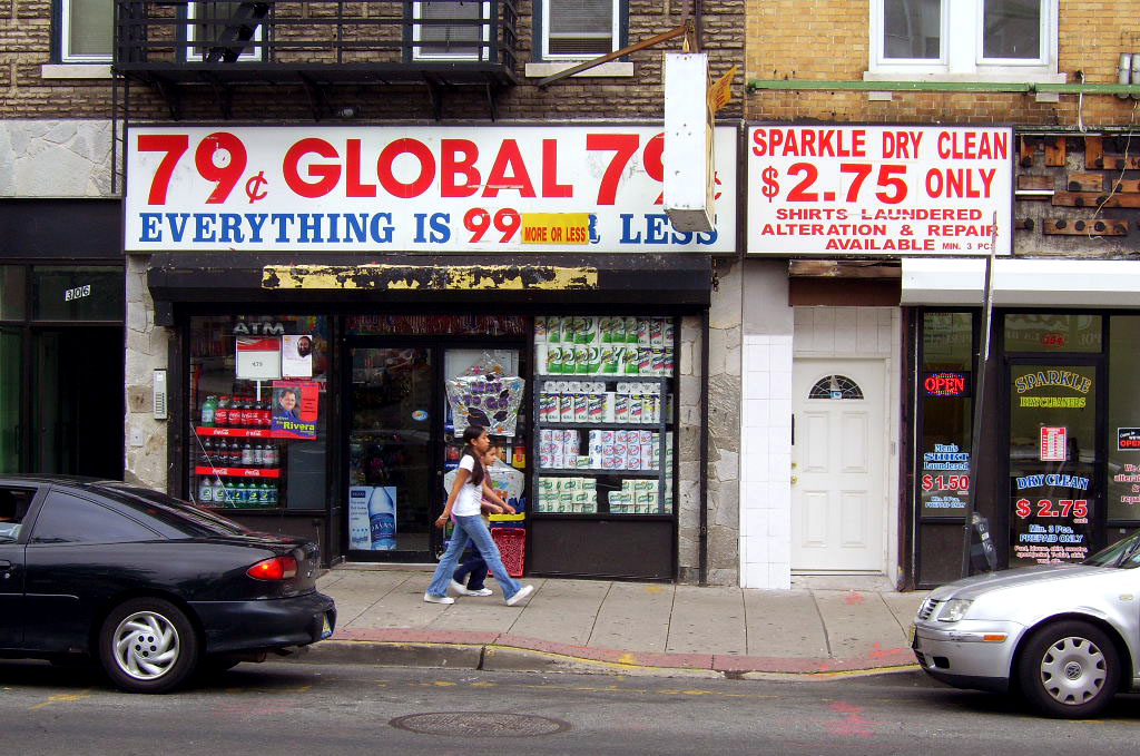 a woman walking past a store with advertising on the front