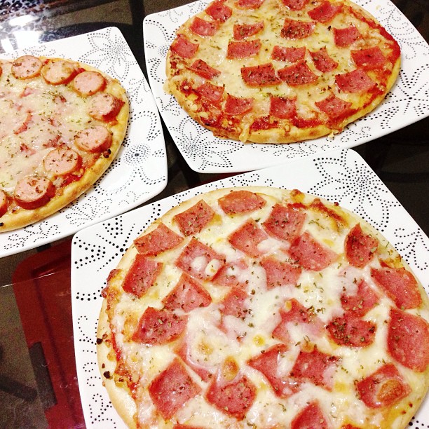 two pizzas are shown on plates in this picture