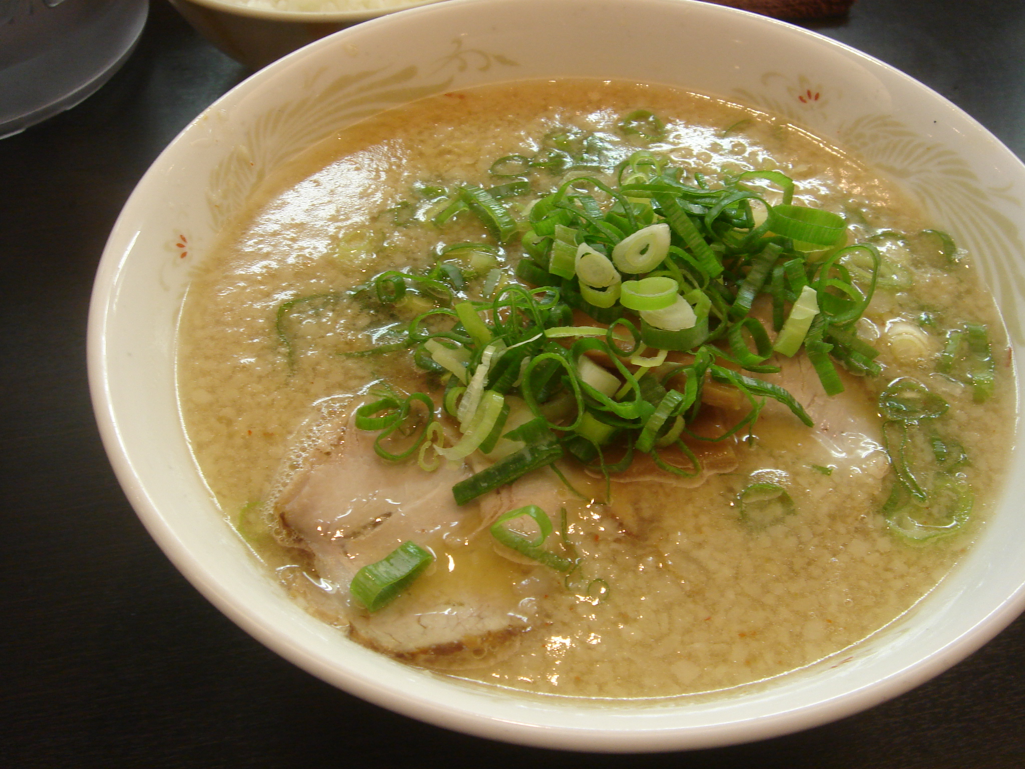 a bowl filled with green onions and soup