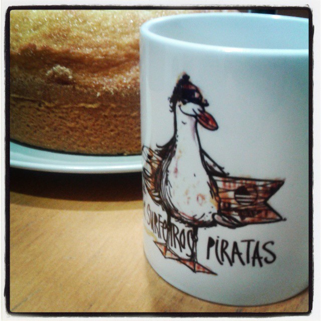 a duck drawn on a coffee cup next to a cake