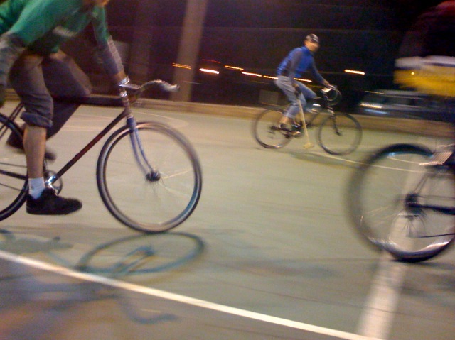 three people are riding bicycles at night on a city street