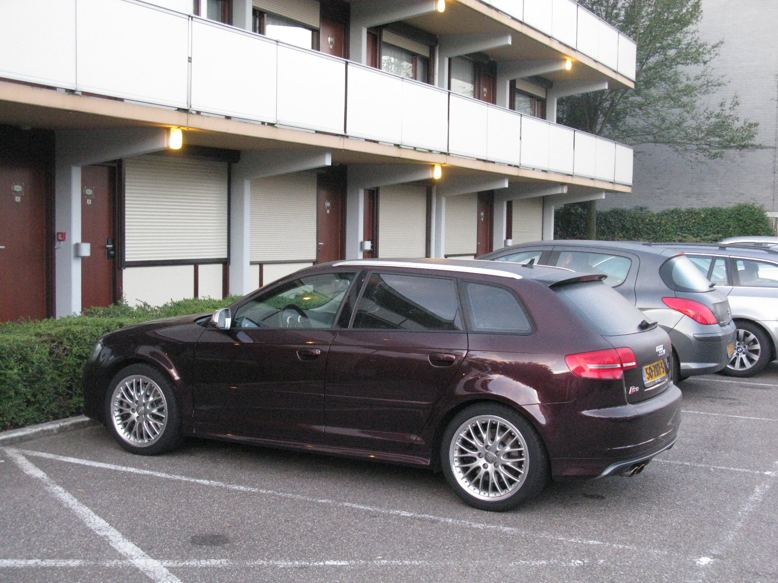 a maroon sports car parked in a parking space