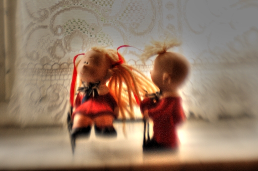 two little doll dolls are posed next to each other