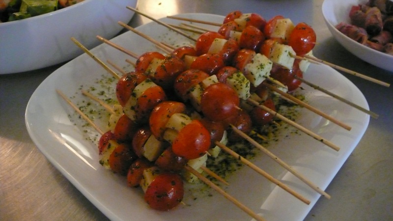 several skewered kebabs sit on a white plate