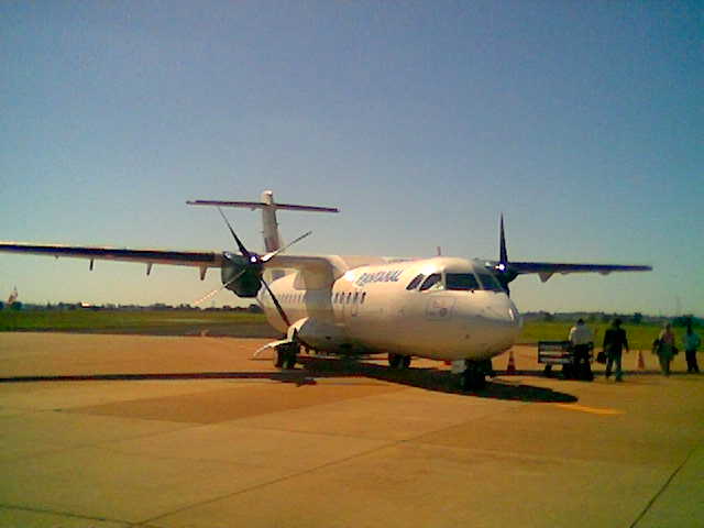 a large propeller plane parked on an airport tarmac