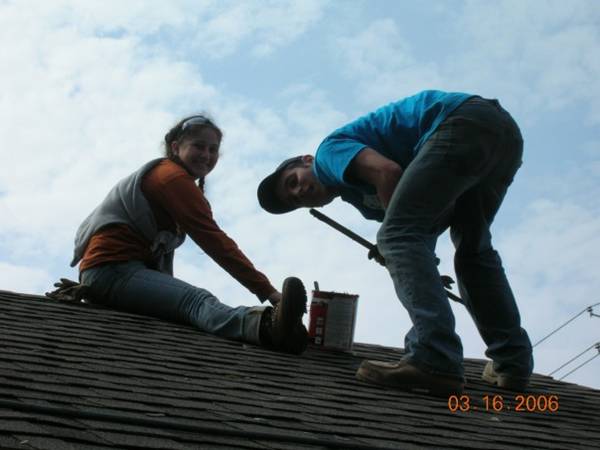 two men with safety helmets working on a roof