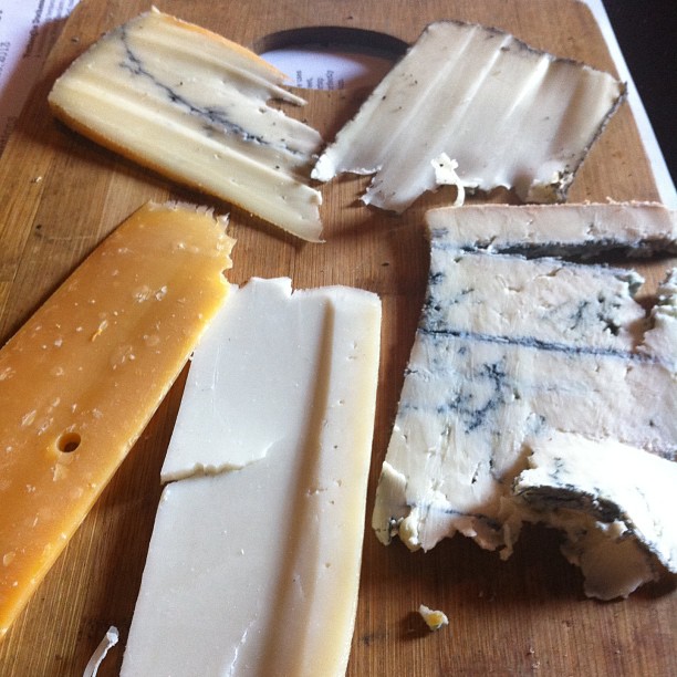 several different kinds of cheeses arranged on a  board