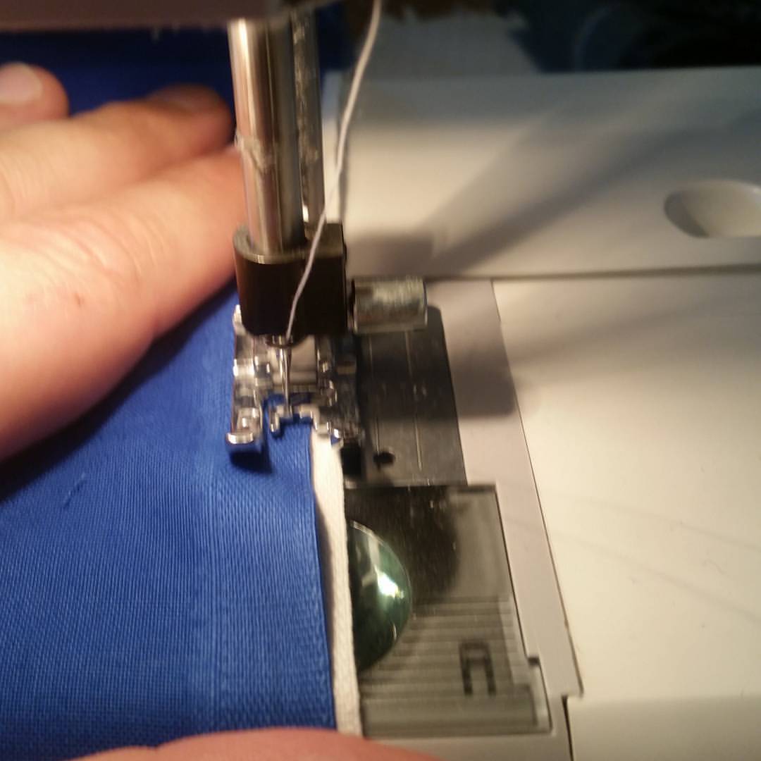 the person is sews the fabric with the sewing machine