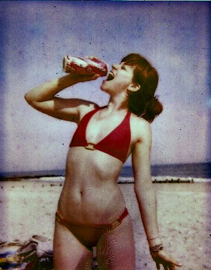 a woman in a bikini drinking a coke drink