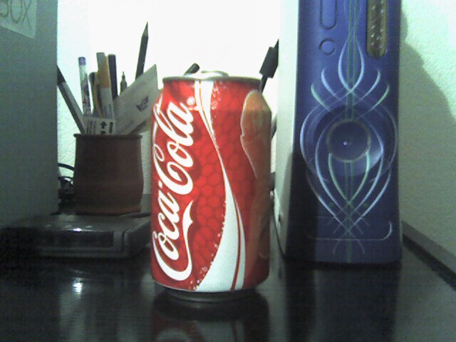 an open can of coke on a counter top