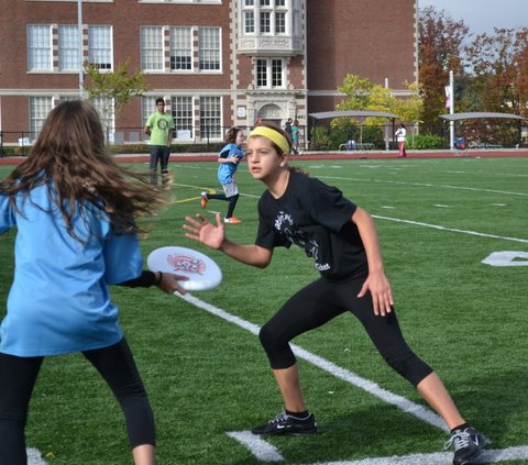 a group of young people on a field playing frisbee