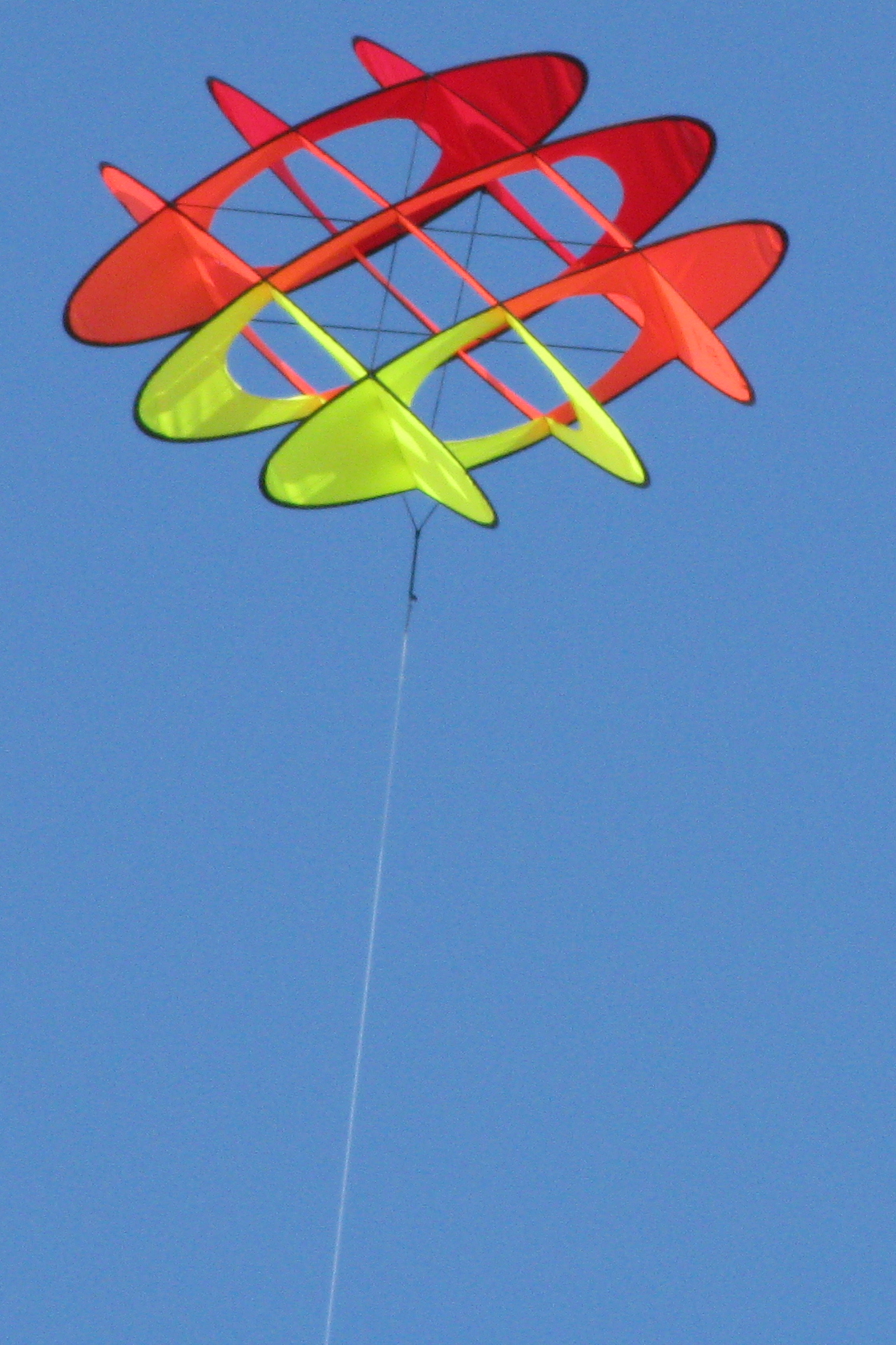 a kite that looks like three fish and is flying in the sky