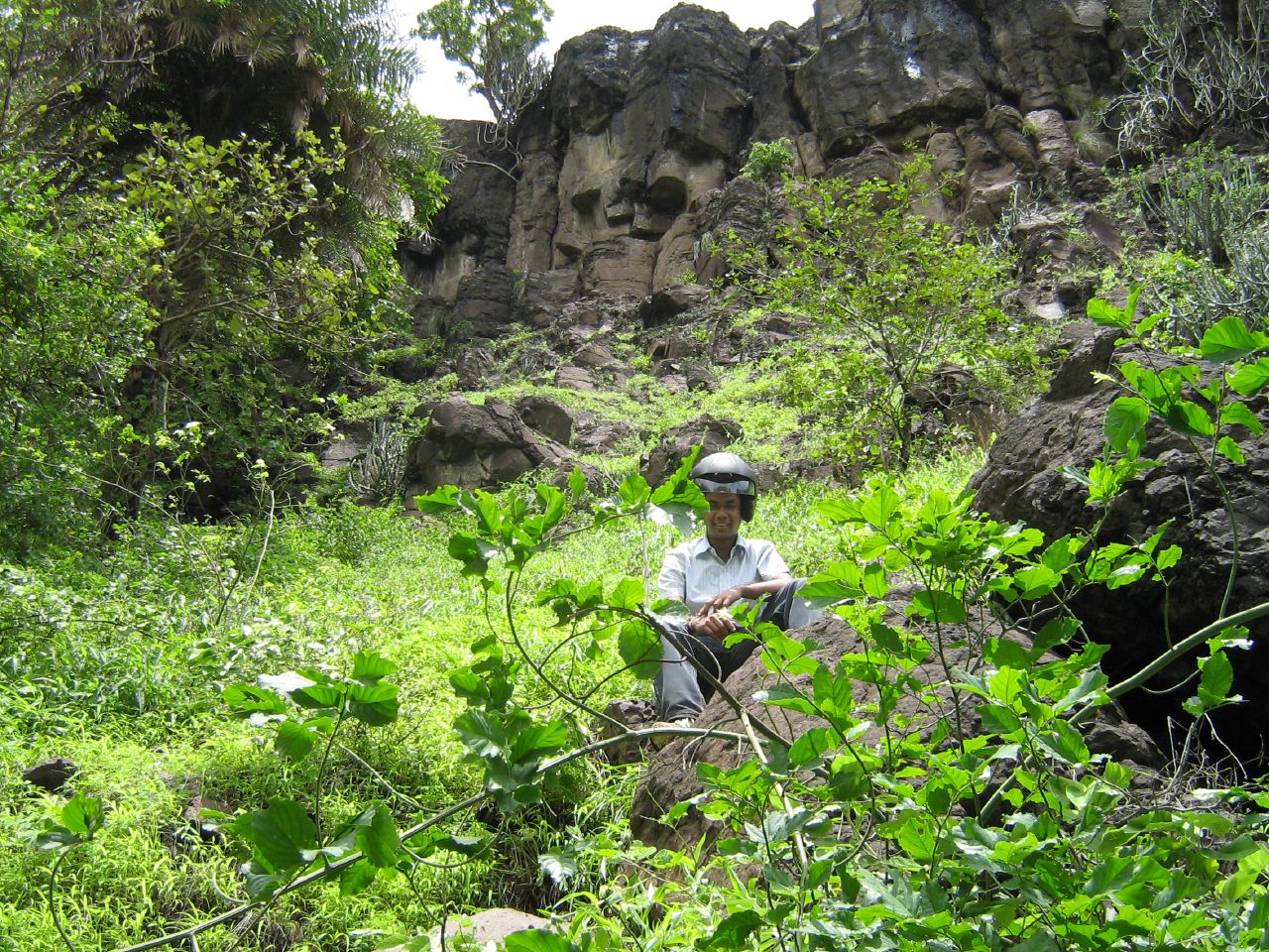 a man stands in a field near the rocks