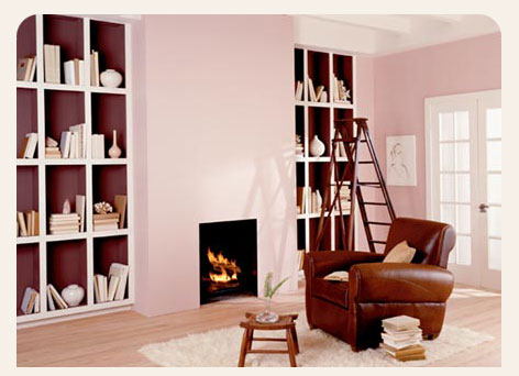 a brown chair sitting in a room with pink walls