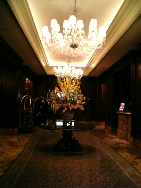large floral arrangement in dark hall with chandelier