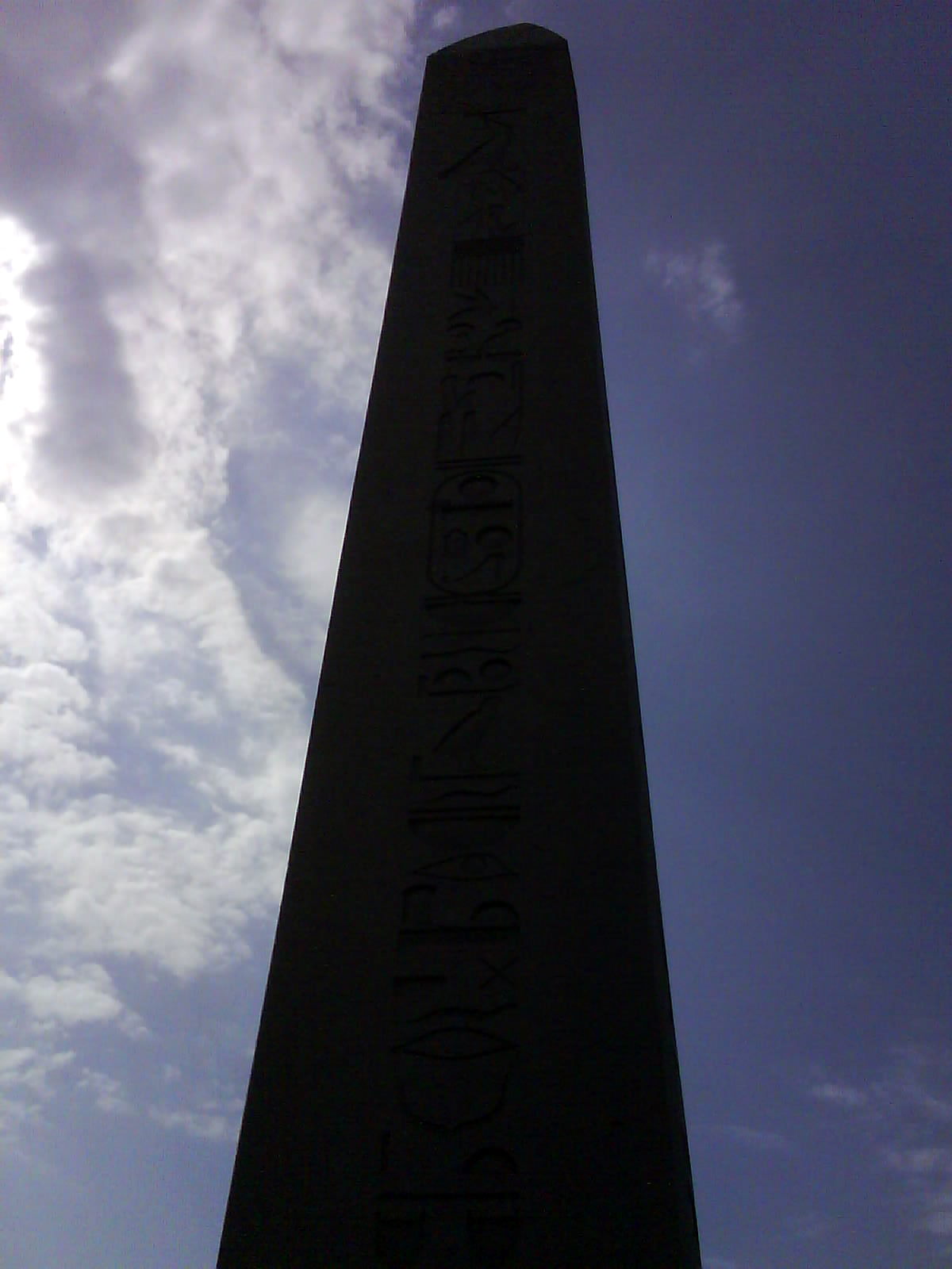 a very tall black monument with a sky background