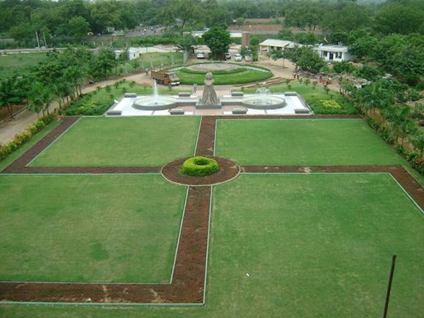 large open yard with circular garden area and fountain in center