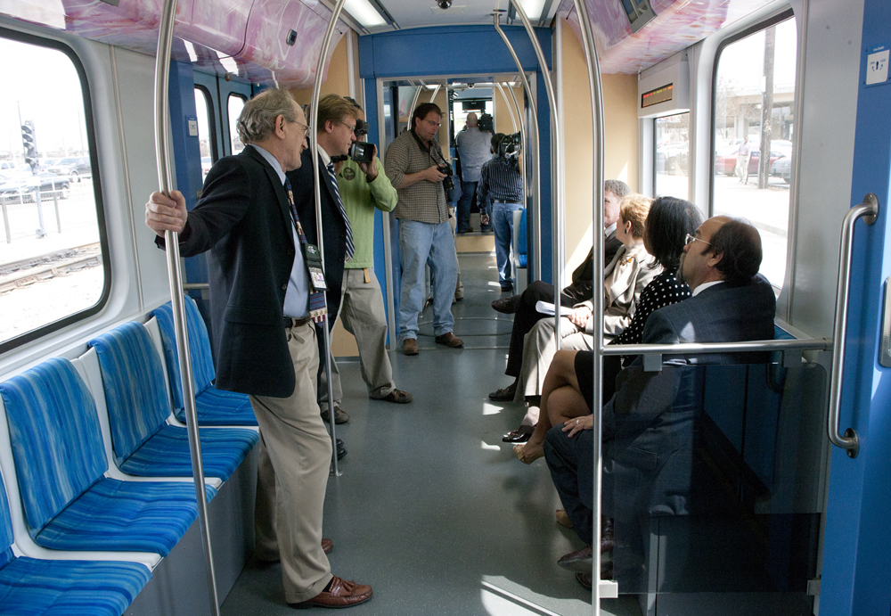 a group of people sitting on some seats in a bus
