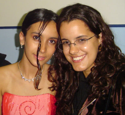 two young women posing for the camera in a public area