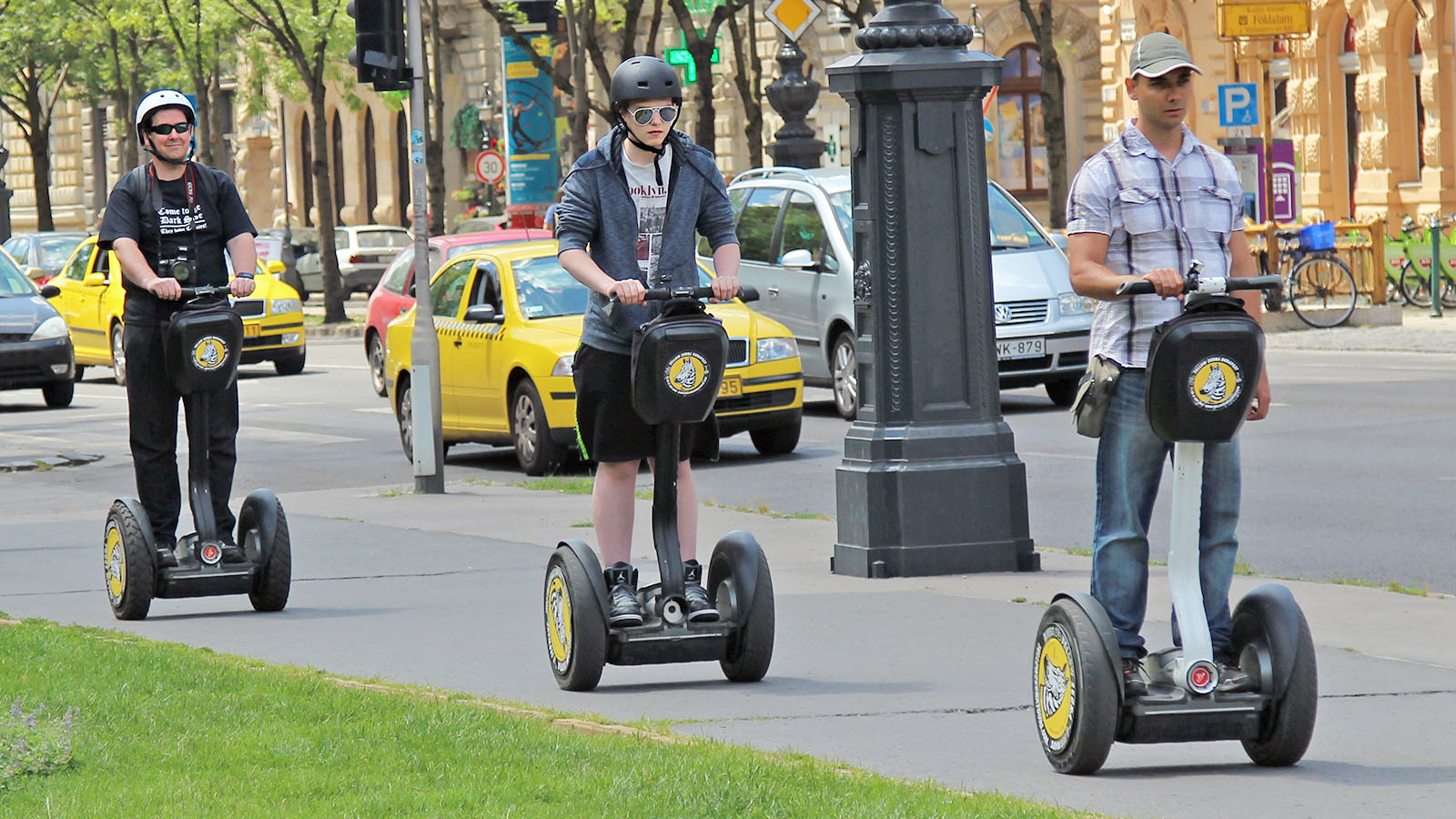 two men on scooters are riding down the street