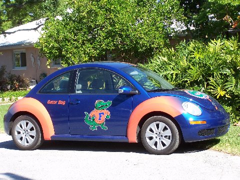 the back end of a blue car with orange trim, painted