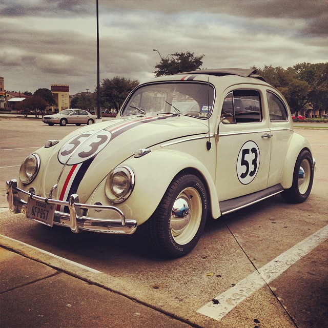 an antique white car with a number on the side