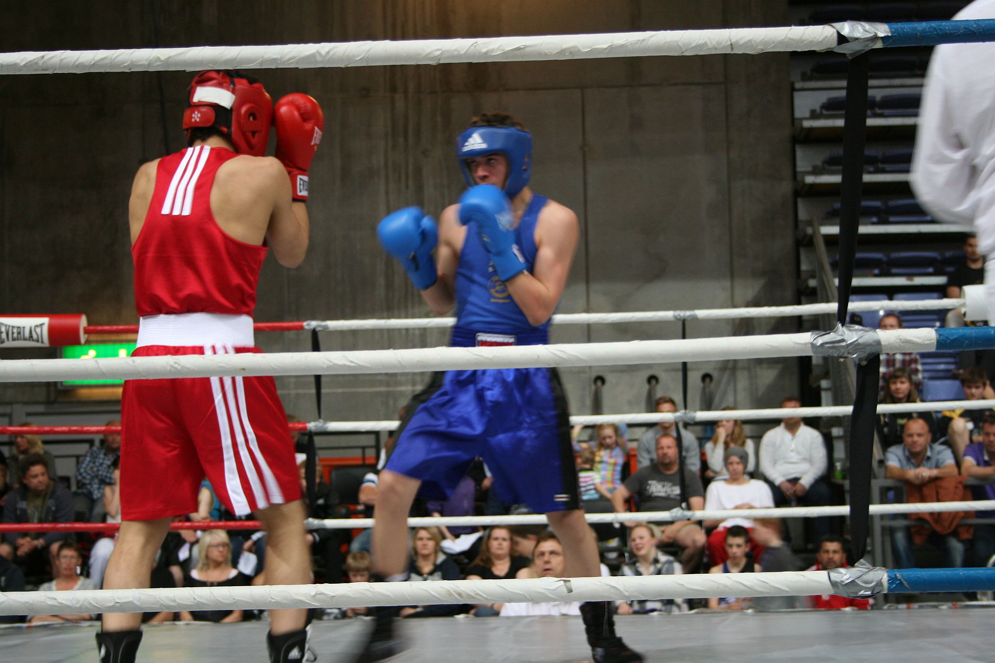 two boxers in red and blue shorts at a boxing match