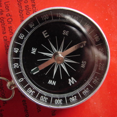a compass with a hook sitting on top of it